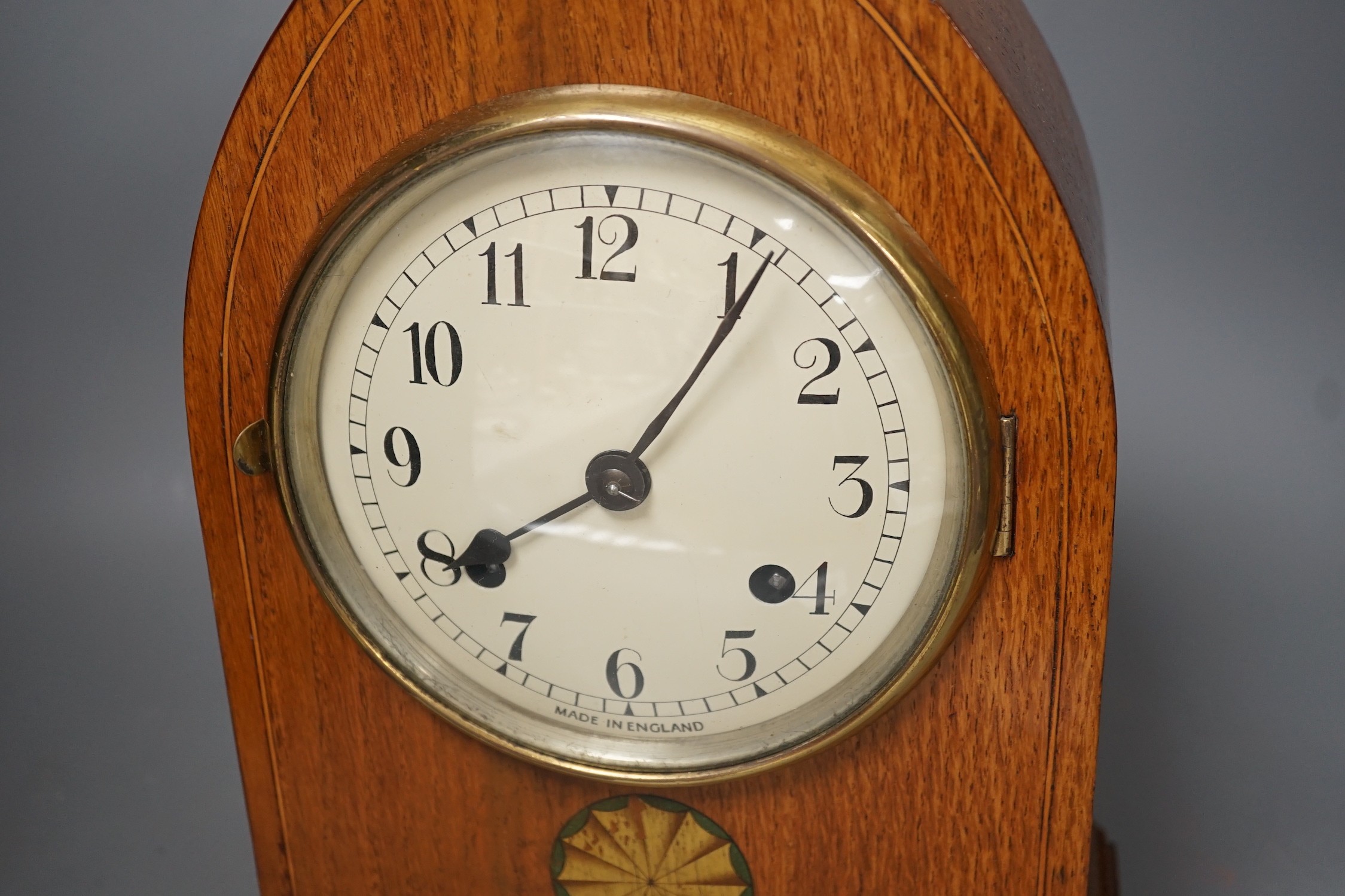 A pair of ebony rhinoceros book ends, together with an Edwardian oak lancet mantel clock, 35cm high